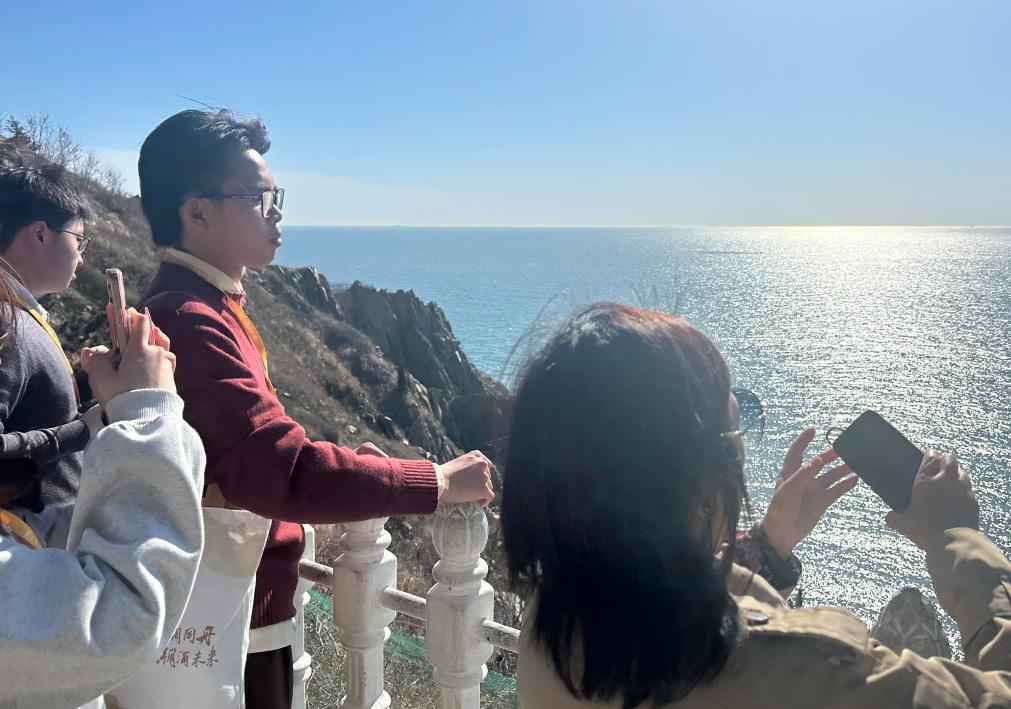 台湾学生简星宇(右二)与同学在大连旅顺老铁山观景台俯瞰黄渤海分界线(4月24日摄)。新华社记者 李妍 摄
