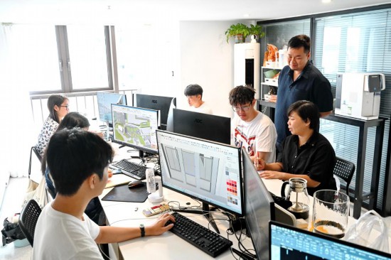 2024年8月14日,台湾青年陈榆文(右一)和创业伙伴陈龙(右二)等在公司办公室讨论设计方案。新华社记者 林善传 摄