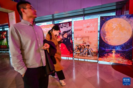 3月31日，在首都电影院西单店，观众从台湾电影《阳光女子合唱团》的海报旁走过。新华社记者 陈晔华 摄