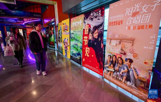 3月31日，在首都电影院西单店，观众从台湾电影《阳光女子合唱团》的海报旁走过。新华社记者 陈晔华 摄